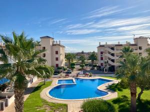 a resort with a swimming pool and palm trees at Penthouse Apartment Orihuela Costa in Orihuela Costa
