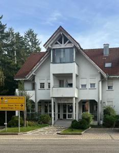 - un grand bâtiment blanc avec un panneau devant dans l'établissement 1 Zimmer Apartment, à Klettgau