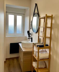 een badkamer met een wastafel en een spiegel bij Flor du Mont Gîte in Pontorson