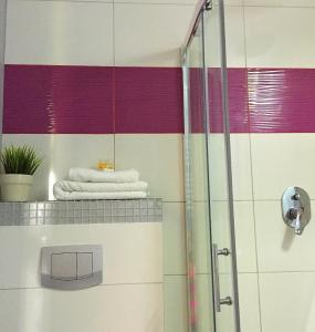 a bathroom with a shower with colorful stripes on the wall at Hotel Perłowy in Okuninka +22 photos