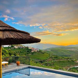 a villa with a swimming pool and a straw umbrella at Casa do Romezal in Peso da Régua +79 photos