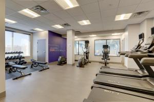 un gimnasio con cintas de correr, equipos de ejercicio y ventanas en Holiday Inn Express Holly Springs - Raleigh Area, an IHG Hotel en Holly Springs