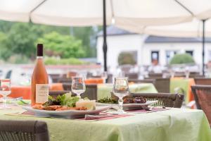 uma mesa com um prato de comida e uma garrafa de vinho em Mobil-home Excellence - 3 Chambres em Chaumont-sur-Loire