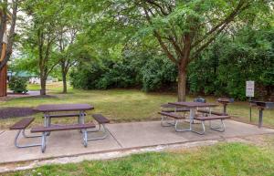 two picnic tables and benches in a park at Studio 6 Extended Stay Fairfield, OH - Cincinnati in Fairfield