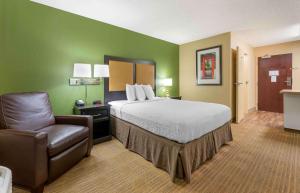 een hotelkamer met een bed en een stoel bij Extended Stay America Suites - Columbus - Worthington in Worthington