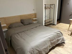 1 dormitorio con 1 cama grande y cabecero de madera en La Cigogne, en Panissières