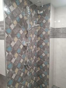 a shower in a bathroom with a tiled wall at Граф игнатиев луксозен апартамент с топ гледка in Yambol