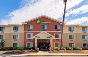 a front view of a hotel with a palm tree at Extended Stay America Suites - Melbourne - Airport in Melbourne