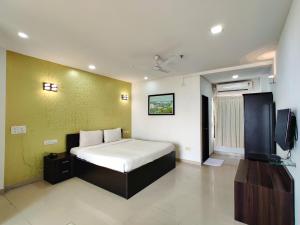 a bedroom with a bed and a television in it at Golden Chariot Hotel Daman in Daman