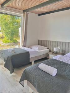 a bedroom with two beds and a large window at Apartamenty Molle in Åkirkeby