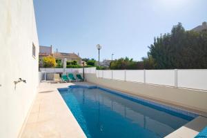 a swimming pool on the side of a house at Vila Alonzo in Albufeira