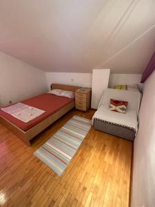 um pequeno quarto no sótão com uma cama e um sofá em Golden Age Hostel em Ohrid