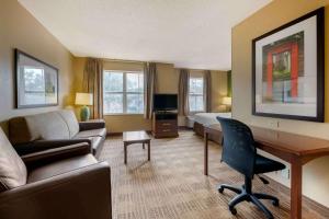 um quarto de hotel com um sofá, uma cama e uma secretária em Extended Stay America Suites - Orlando - Convention Center - 6443 Westwood em Orlando