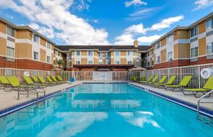uma piscina com espreguiçadeiras e um hotel em Extended Stay America Suites - Orlando - Convention Center - Universal Blvd em Orlando