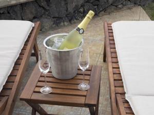 a bottle of wine in a bucket on a table with wine glasses at Villa Charly in Puerto de la Madera