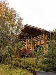 uma cabana de madeira no meio de um jardim em Царська Долина em Neresnytsya