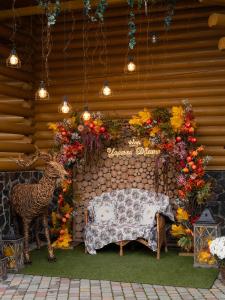a wooden wall with a table and flowers and lights at Царська Долина in Neresnytsya