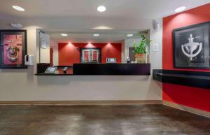 una sala de espera con paredes rojas y un espejo en Extended Stay America Suites - Orlando - Lake Mary - 1036 Greenwood Blvd en Lake Mary