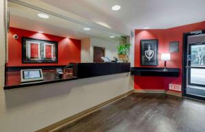 a restaurant with a red wall and a counter at Extended Stay America Suites - Orlando - Lake Mary - 1036 Greenwood Blvd in Lake Mary