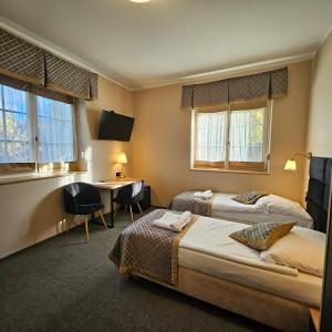 a hotel room with two beds and a desk at Willa Kłodzko - Zacisze in Kłodzko