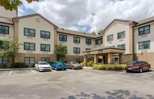 Extended Stay America Select Suites - Orlando - Maitland - 1760 Pembrook Dr في أورلاندو: مبنى كبير به سيارات تقف في موقف للسيارات