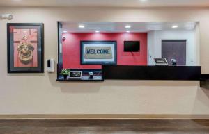 a lobby with a red wall with a welcome sign at Extended Stay America Select Suites - Orlando - Maitland - 1760 Pembrook Dr in Orlando