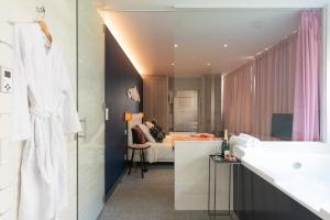 een badkamer met een wastafel en een slaapkamer bij A coté de la place du pilori in Angers