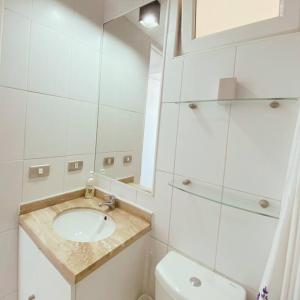 La salle de bains blanche est pourvue d'un lavabo et de toilettes. dans l'établissement Departamento en Punta Puyai frente al océano, à Papudo