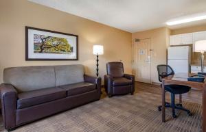 a living room with a couch and a desk and a kitchen at Extended Stay America Suites - Orlando - Maitland - 1776 Pembrook Dr in Orlando