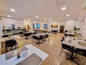 a dining room with tables and chairs and a cafeteria at Canas Gold Praia Hotel in Florianópolis