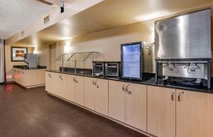 a large kitchen with wooden cabinets and a large appliance at Extended Stay America Suites - Orlando - Orlando Theme Parks - Major Blvd in Orlando