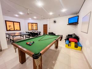 sala de estar con mesa de billar y TV en Canas Gold Praia Hotel, en Florianópolis