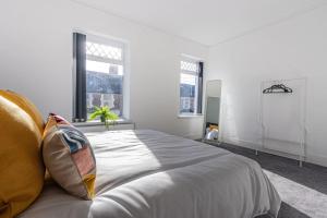 een witte slaapkamer met een groot bed en 2 ramen bij New Stylish 5BD, 5min from town in Cardiff