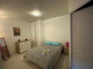 ein kleines Schlafzimmer mit einem Bett und einem Nachttisch in der Unterkunft T2 rdc Muret in Muret