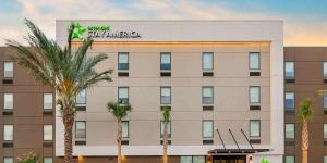 ein Hotel mit Palmen vor einem Gebäude in der Unterkunft Extended Stay America Premier Suites - Orlando - Sanford in Sanford