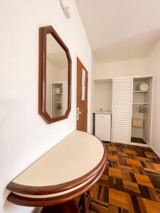 um quarto com uma mesa e um espelho em Canas Gold Praia Hotel em Florianópolis