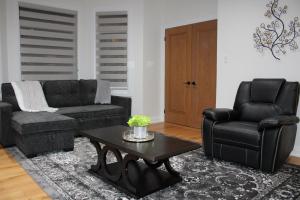 sala de estar con sofá, silla y mesa en Where Luxury Retreat meets Convenience!, en Tottenham