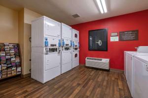 eine Waschküche mit weißen Geräten und einer roten Wand in der Unterkunft Extended Stay America Suites - Jacksonville - Riverwalk - Convention Center in Jacksonville