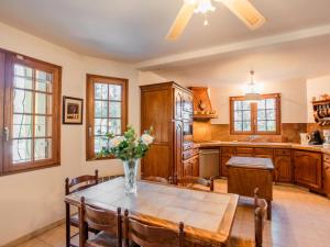 een keuken met een tafel met daarop een vaas met bloemen bij La grande Sorgues in Sorgues