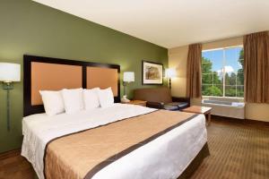 a hotel room with a large bed and a window at Extended Stay America Suites - Clearwater - Carillon Park in Clearwater