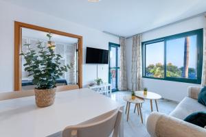 ein Wohnzimmer mit einem weißen Tisch und einer Topfpflanze in der Unterkunft 797 HOLIDAY RENTALS - Apartamento en Pueblo del Parque in Arroyo de la Miel