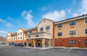 un gran edificio con coches estacionados en un estacionamiento en Extended Stay America Suites - Pensacola - University Mall en Pensacola