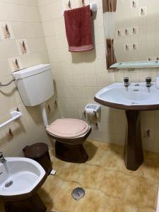 a bathroom with a toilet and a sink at Quarto casa familiar in Viseu