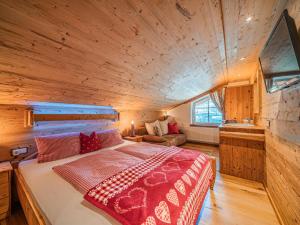 a bedroom with a large bed in a wooden room at Hilde 1 in Kirchdorf in Tirol