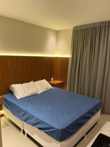 um quarto com uma cama grande e um cobertor azul em CASA ALTO DA ENSEADA PRAIA DO FORTE na Praia do Forte