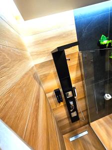 ein Badezimmer mit Holzböden und eine Wand mit einer Tür in der Unterkunft Trilogy Prestige - Central Premium Suites in Lecce