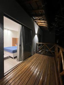 een slaapkamer met een bed en een groot glazen raam bij CASA ALTO DA ENSEADA PRAIA DO FORTE in Praia do Forte