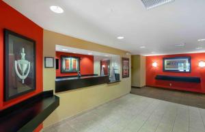 Extended Stay America Suites - Tampa - Airport - Spruce Street في تامبا: لوبي الفندق بجدران برتقالية ومغسلة