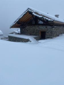 un edificio cubierto de nieve con techo en Chalet 1829 en Sainte-Foy-Tarentaise