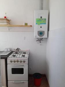 een keuken met een fornuis en een witte oven bij depto 6 personas en costa argentina in Miramar